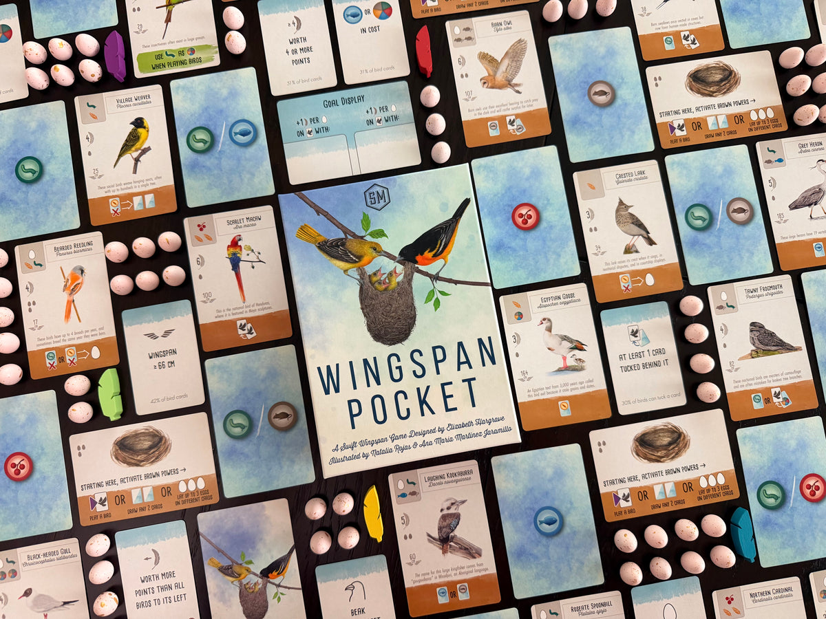 The board game Wingspan Pocket is shown from a top-down angle, featuring a central game board with illustrated bird cards, small round bird eggs, and a winding wooden path.